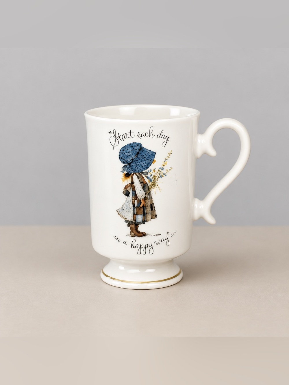Holly Hobbie porcelain pedestal mug features Start Each Day in a Happy Way